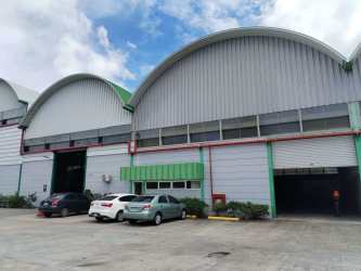 Empty interior of industrial warehouse with high curved metal roof and reinforced steel structure in La Chorrera Panama