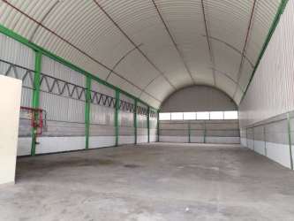 Large interior of empty warehouse showing rolling industrial door and high ceiling La Chorrera Panama
