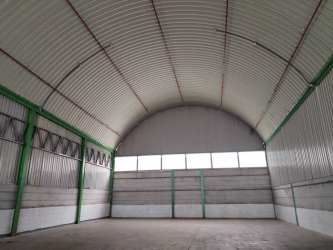 Large empty warehouse space with arched metal roof and concrete flooring in La Chorrera Panama
