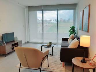 Bright master bedroom with tiled floors, window, and walk-in closet at The District Costa Verde