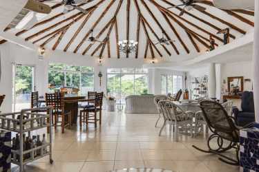 Covered terrace with hammocks, stone pillars, garden view at Punta Barco villa Panama