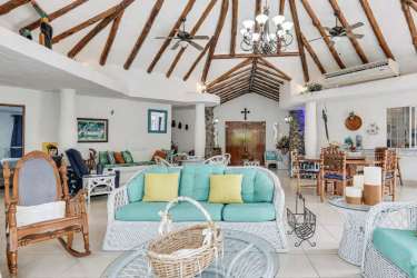 Living room with exposed beams, large windows, tiled floors Punta Barco luxury villa Panama