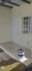 Covered entry porch with white door and window at Mendoza Valley residential Panama