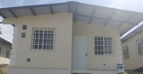 Front view of cream single-story house with roof and barred windows at Mendoza Valley Costa Verde Panama