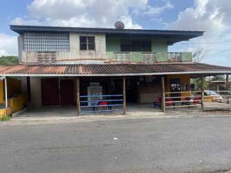Colorful two-story commercial building with parking along street La Chorrera Panama