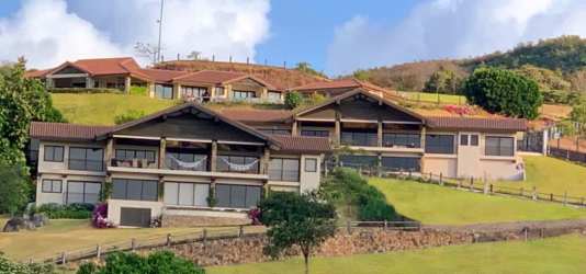 Aerial view over green rolling hills and open plot at Rancho Santa Fe Las Lajas mountain community Panama