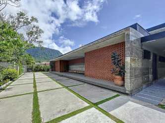 Two-story modern house with glass doors, green lawn and mountain views in El Valle de Antón Panama
