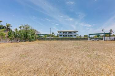 Unbuilt sandy beachfront land with Pacific Ocean and blue sky