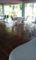 Covered patio with terracotta tile and wood furniture on Veraguas farmhouse