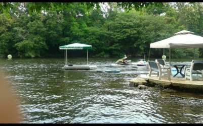 Floating dock on Río Santa María with canopy umbrellas and outdoor furniture