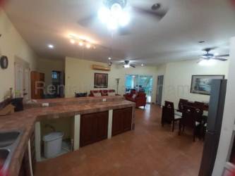 Covered sunroom patio with lounge furniture overlooking private pool in Coronado beach home