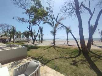 Bedroom with wood floors and large windows overlooking gardens in Playa Caracol condos