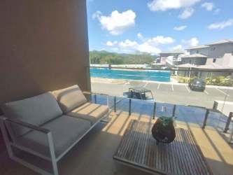Modern pool area with loungers and ocean view in beachfront Playa Caracol condos Panama