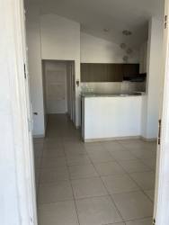 Minimalist kitchen and hallway with breakfast bar tiled floors rental house Residencial Aragón