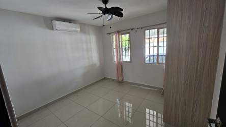 Empty bedroom with neutral walls, tiled floors, ceiling fan and air conditioning in house PH Spring Hills Costa Verde Panama