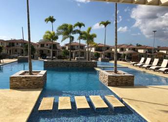 Outdoor swimming pool with lounge chairs and palm trees at PH Spring Hills Costa Verde Panama