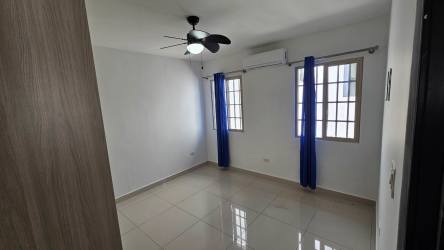 Bright bedroom with built-in wooden wardrobe and ceiling fan at PH Spring Hills Costa Verde Panama