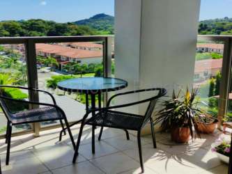 Balcony with black chairs and glass table overlooking mountains in PH Woodlands Panama Pacifico