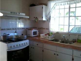 Spacious kitchen with traditional cabinets, gas stove, refrigerator in house near Circunvalación Chitré Panama