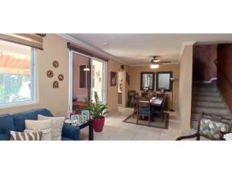 Dining room adjoining kitchen with breakfast bar and ceramic floors in house at Bosques del Pacífico Panama