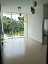 Well-lit living room with sliding glass doors opening to balcony in PH Natura Costa Verde Panama