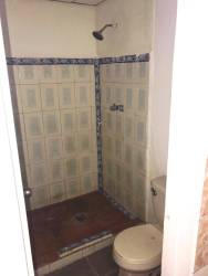 Small bathroom with walk-in shower fully tiled in affordable house Panama