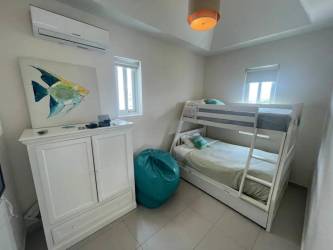 Small bedroom with bunk beds teal bean bag AC wall art Bijao Panama