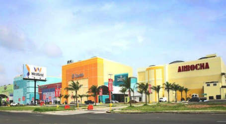 Interior public concourse with retail stores, tiled floors, people sitting and walking at Westland Mall Panama