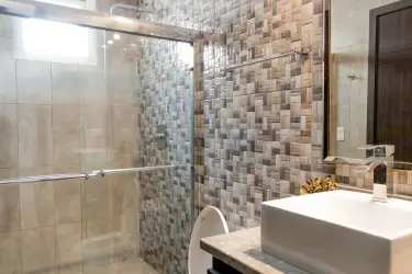 Contemporary bathroom with glass shower, vanity sink, tile walls at Tucán Country Club Cocolí Panama