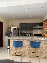Modern kitchen with granite counter, blue bar stools, appliances Volcán Panama house