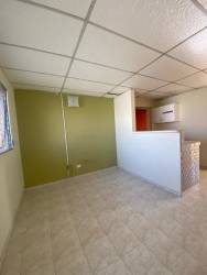 Simple living area with tile flooring and green accent wall affordable house Panamá