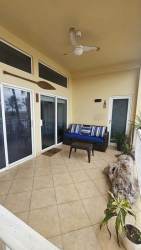 Living area with sliding glass doors to oceanfront balcony, gray sofa coastal decor Las Olas Chiriquí Panama