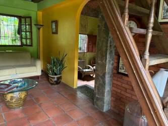 Rustic tropical interior with exposed beams, colorful walls, spacious living area, Panama