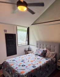 Dining room with glass dining table, upholstered chairs, modern lighting in PH Nativa Panama