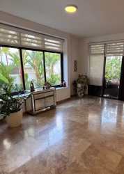 Bright sunroom or living area with marble flooring and garden view at PH Nativa Panama Pacifico