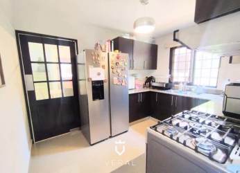 Dining area near staircase with large windows, bright interior in Costa Verde house
