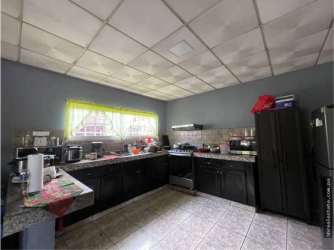 Spacious kitchen with large window, tile counters, dark cabinets in residence Lassonde David Chiriquí