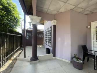 Exterior gravel courtyard surrounded by single-story apartments and trees in David Panama