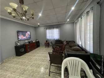 Spacious living room with sofas, gray walls, chandelier and window at investment house in David Panama
