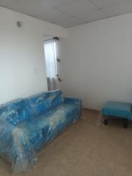 Small living room with blue couch covered in plastic minimalist affordable La Chorrera Panama