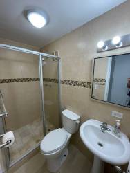 Empty living room with beige ceramic tiles and neutral walls at La Primavera Arraiján