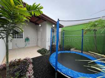 Suburban house rooftops with solar panels, fenced yards and security wall at Brisas del Golf Arraijan Panama