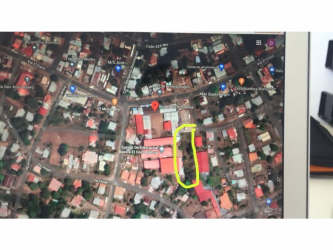 Partially cleared field with trees and open green area on fenced lot in El Coco La Chorrera Panama