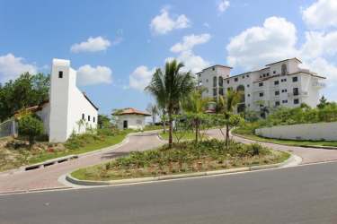 Multi-story white Mediterranean residential complex on a hillside with lush landscaping at Islamar Vistamar Panama