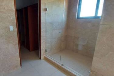 Spacious contemporary bathroom with double sink vanity and beige stone tiles at Islamar Vistamar Golf Beach Marina Panama