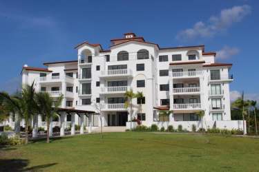 Modern bathroom with beige tiles, glass enclosed walk-in shower and window in Islamar villa Vistamar Panama