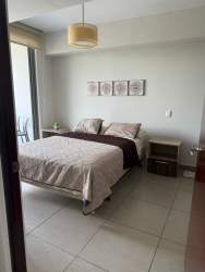 Living room with large window, access to balcony, contemporary furniture at Casco Pacifico Panama