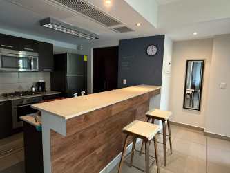 Modern kitchen with granite counters, appliances, open to dining area at Casco Pacifico Panama