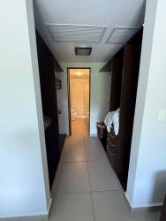 Second fully furnished bedroom with large window and tile floors at Casco Pacifico Residences Panama