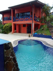 Private outdoor swimming pool surrounded by tropical landscaping in mountain house Altos del María